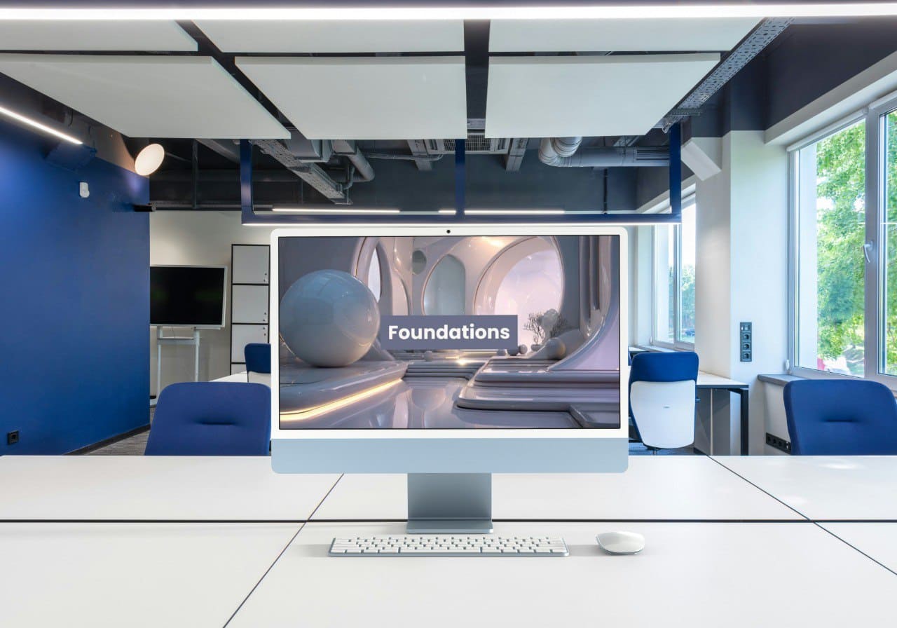 Modern office space with a computer displaying 'Foundations' on a screen.