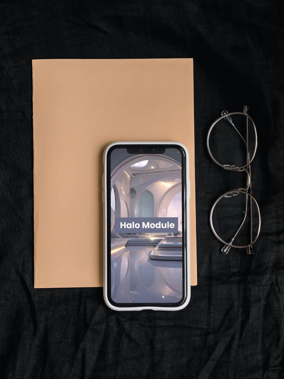 Phone with 'Halo Module' course display on a brown paper background with eyeglasses.