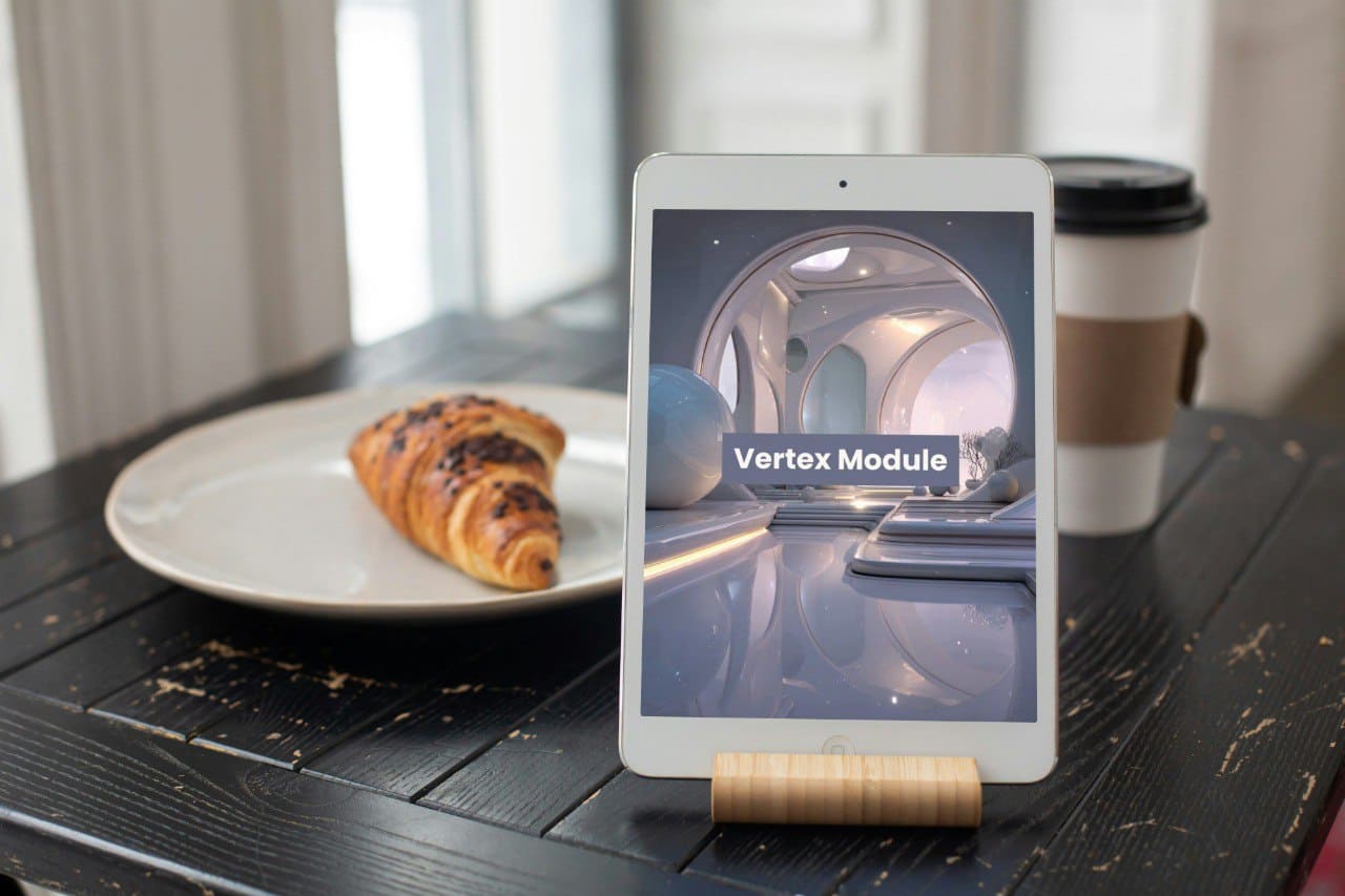 Tablet on a stand displaying 'Vertex Module' course, next to a croissant and coffee cup on a wooden table.